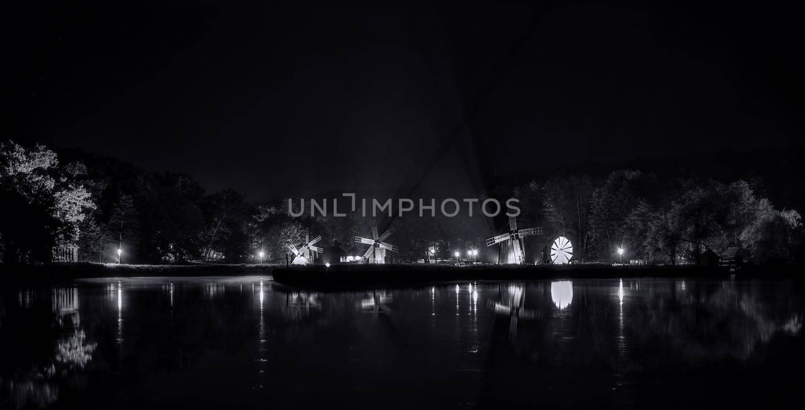 Windmills on lake by night