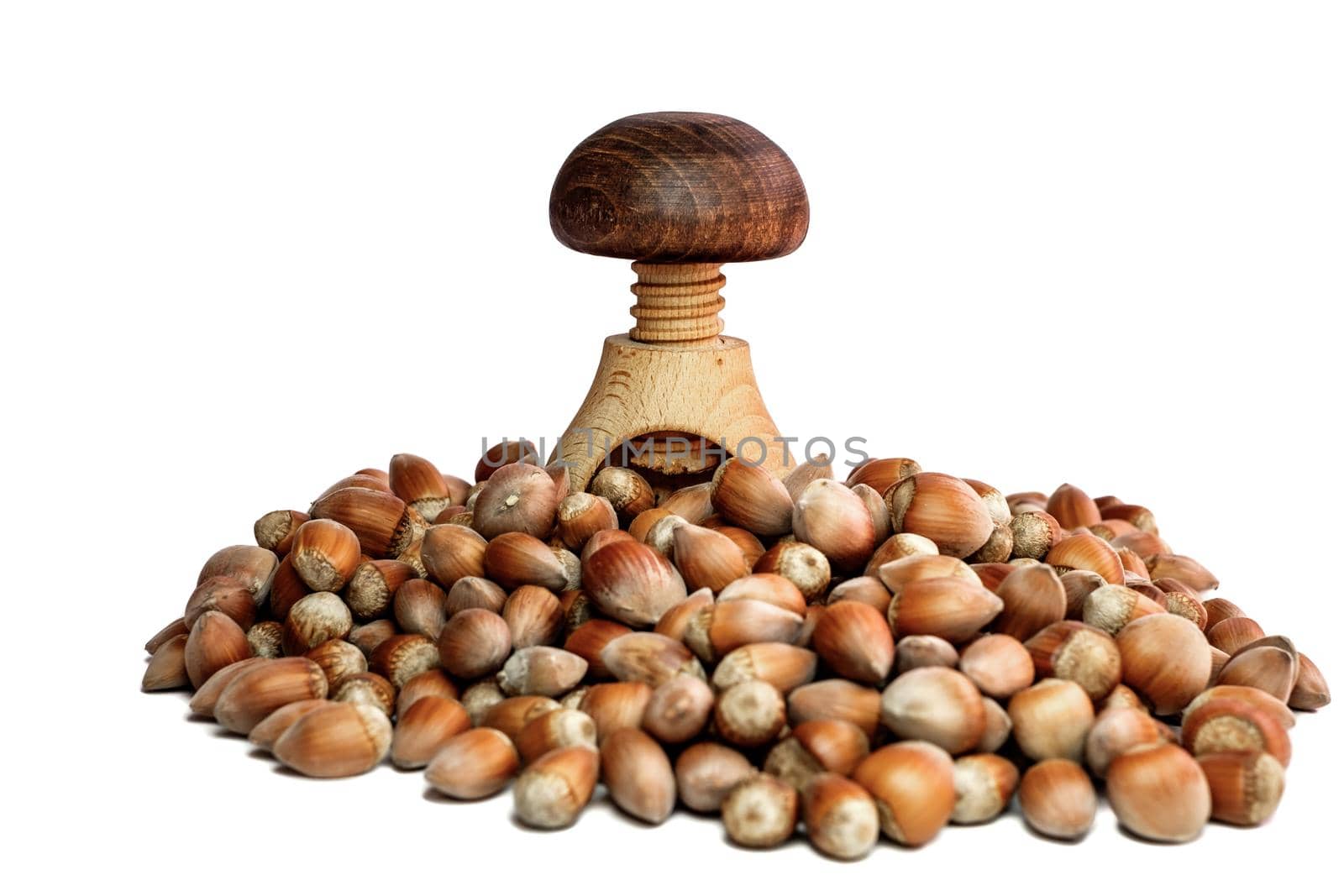 wooden nutcracker and hazelnuts on white background