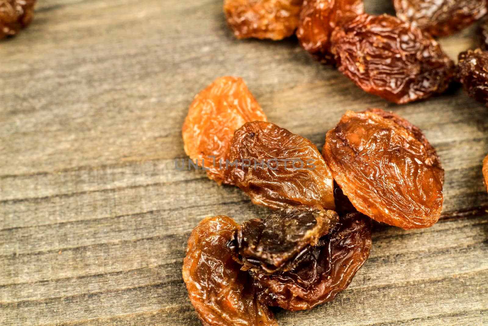 Tasty sultana raisins on gray wooden board