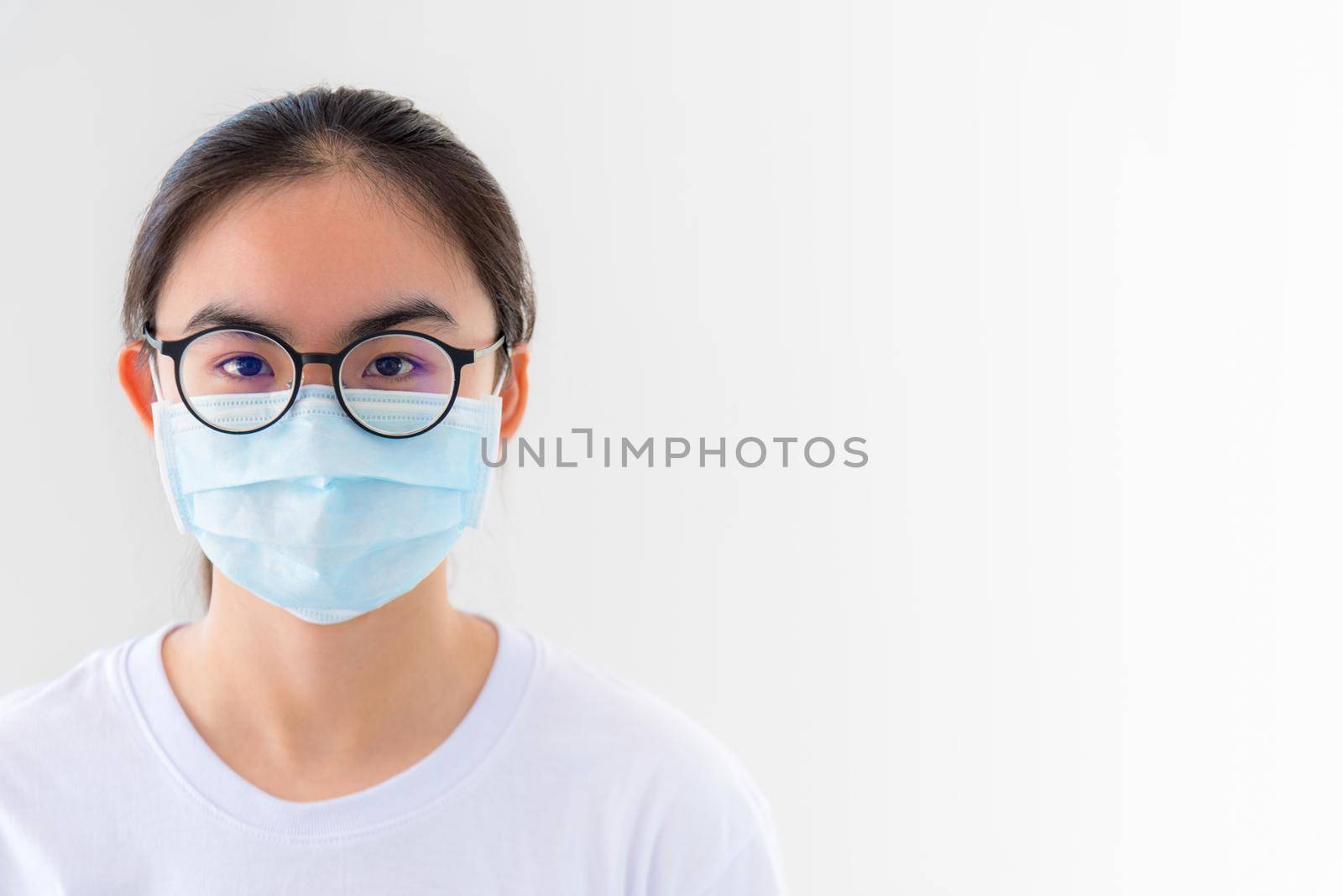 Closeup face Asian young woman wears glasses and mask to protect against Coronavirus looking at camera, Thailand girl people on white background blank or copy space for anti virus Covid 19 concept