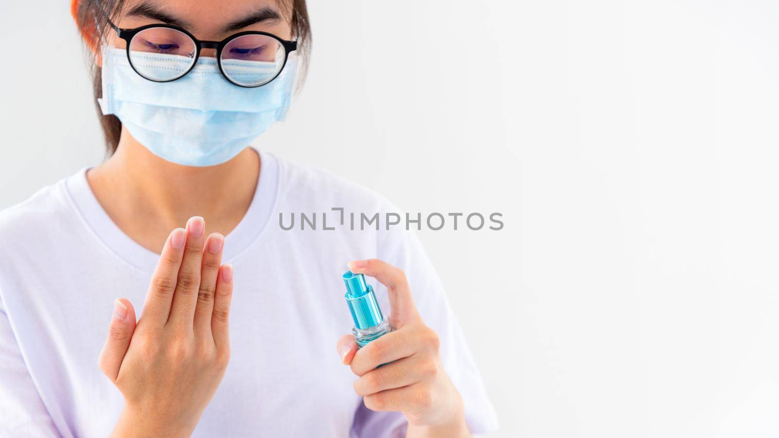 Asian young woman wears mask protect wash hand cleaning with alcohol spray stop coronavirus outbreak or prevent the spread of the Covid 19 virus isolated on white background, Good hygiene concept 16:9