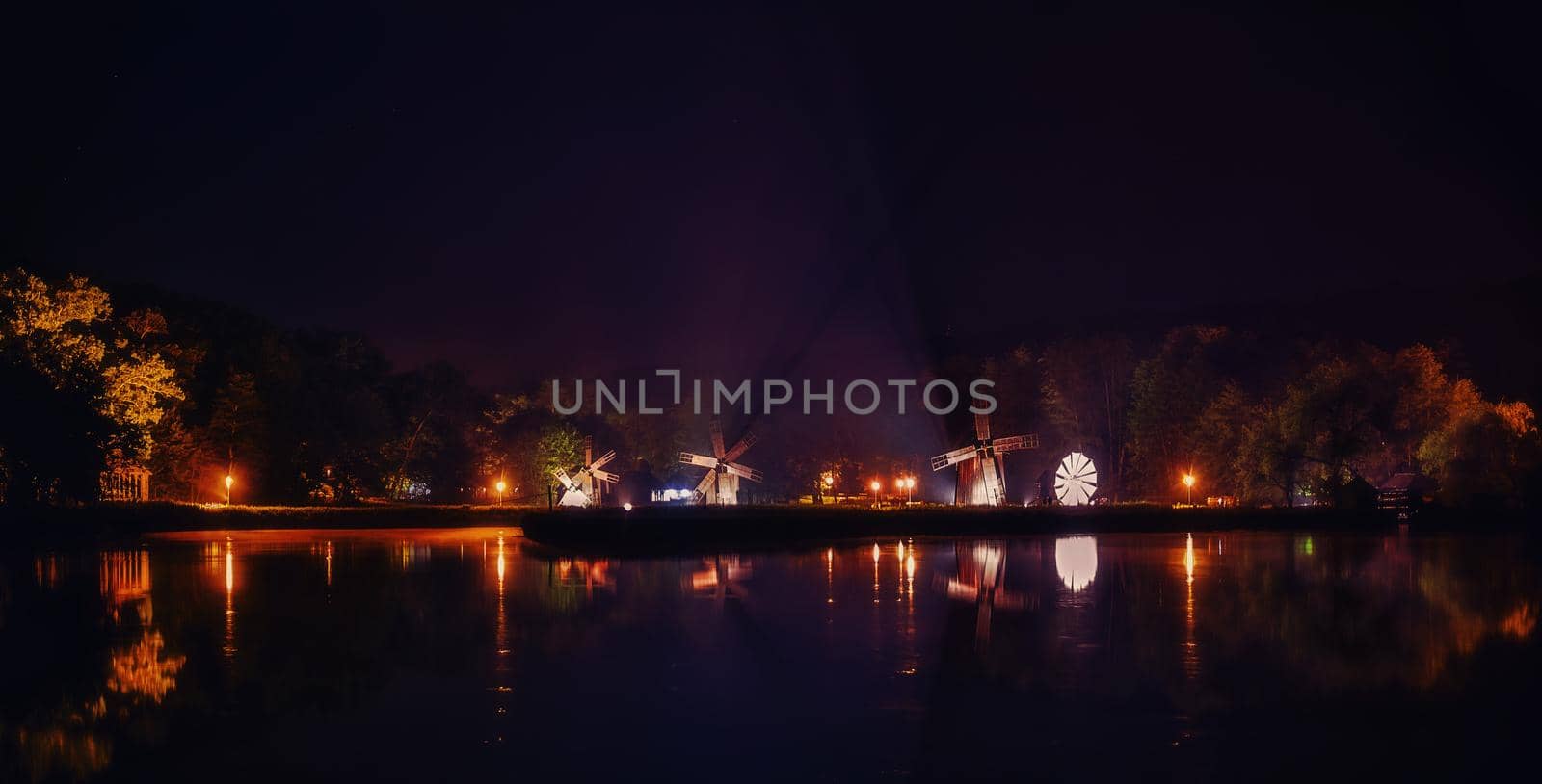 Windmills on lake by night