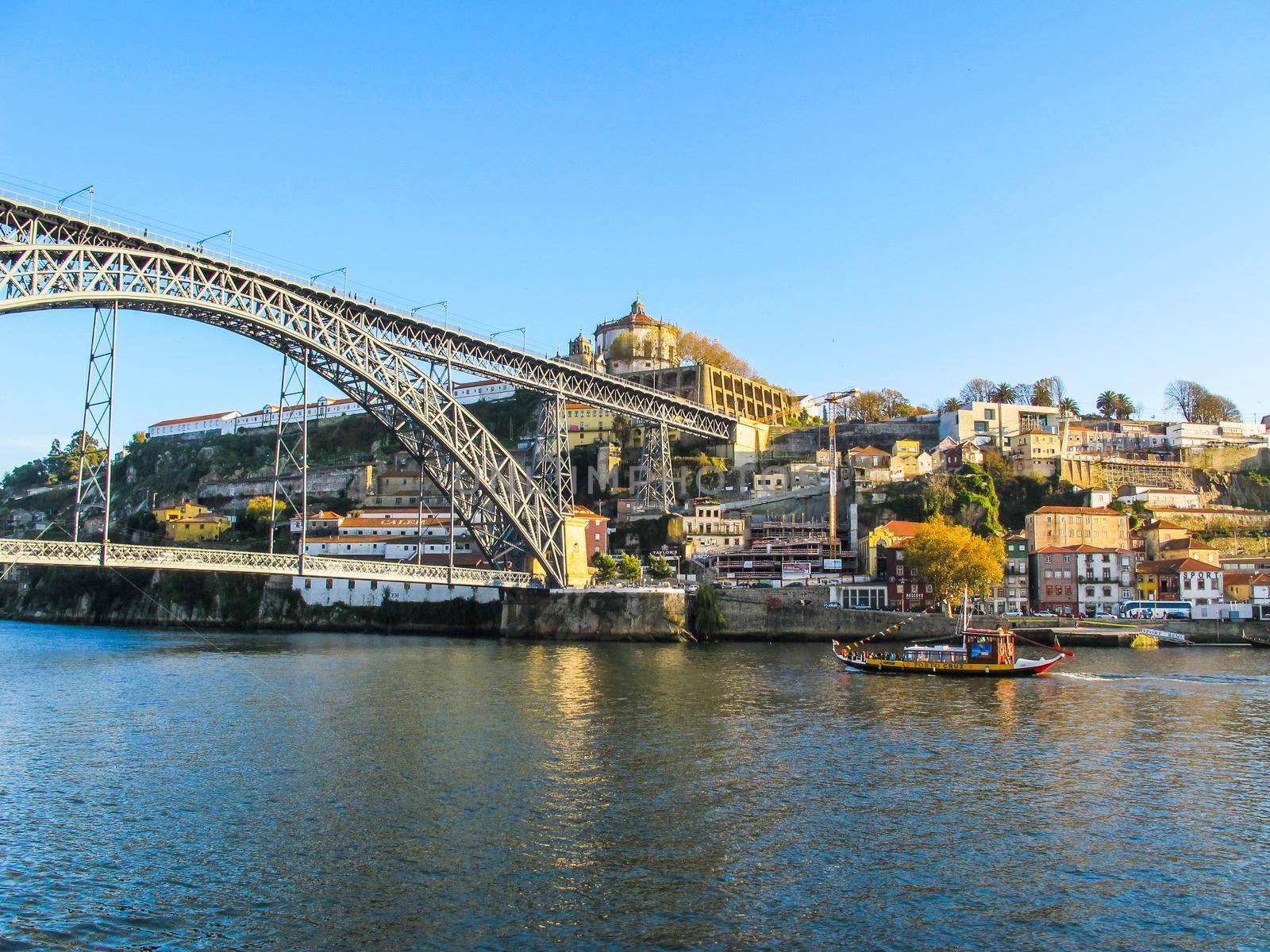 Porto / Portugal - November 27 2010: Panorama of the city, metallic Dom Luis bridge over Douro river and tourist Rabelo Boat