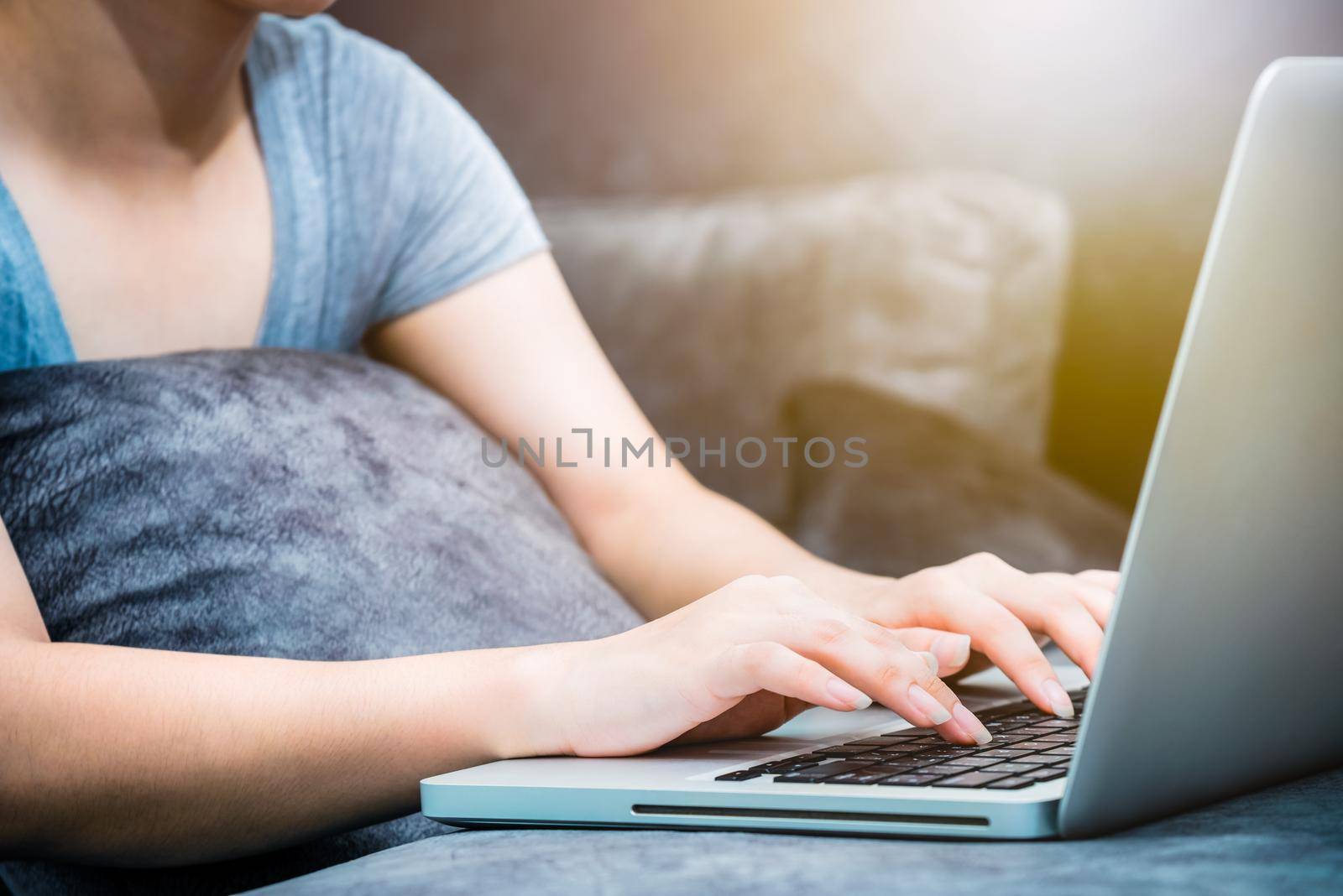 Closeup of a woman's hand on a laptop by Yongkiet