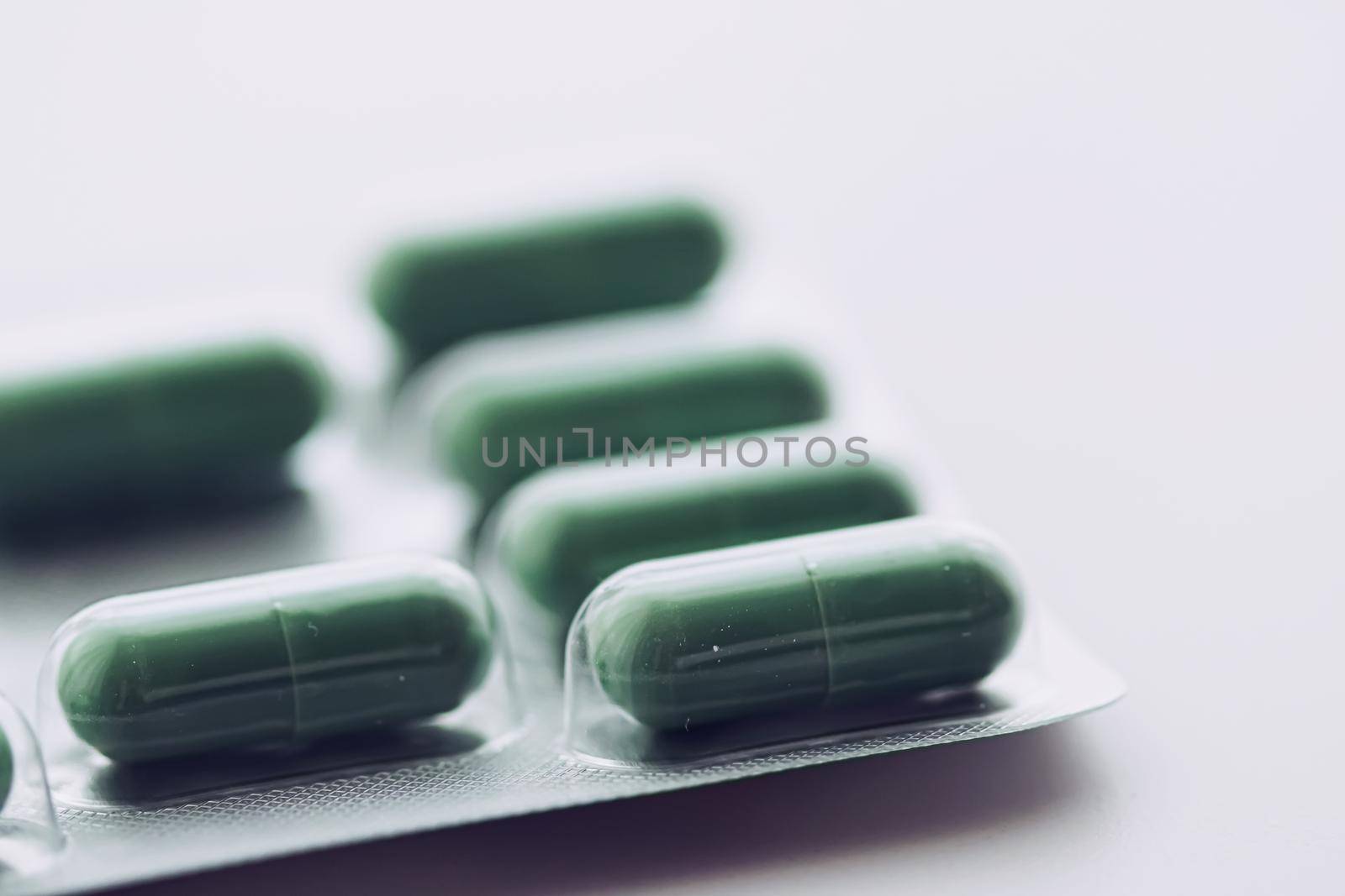 Green pills and capsules as nutrition supplement, wellness and healthcare concept