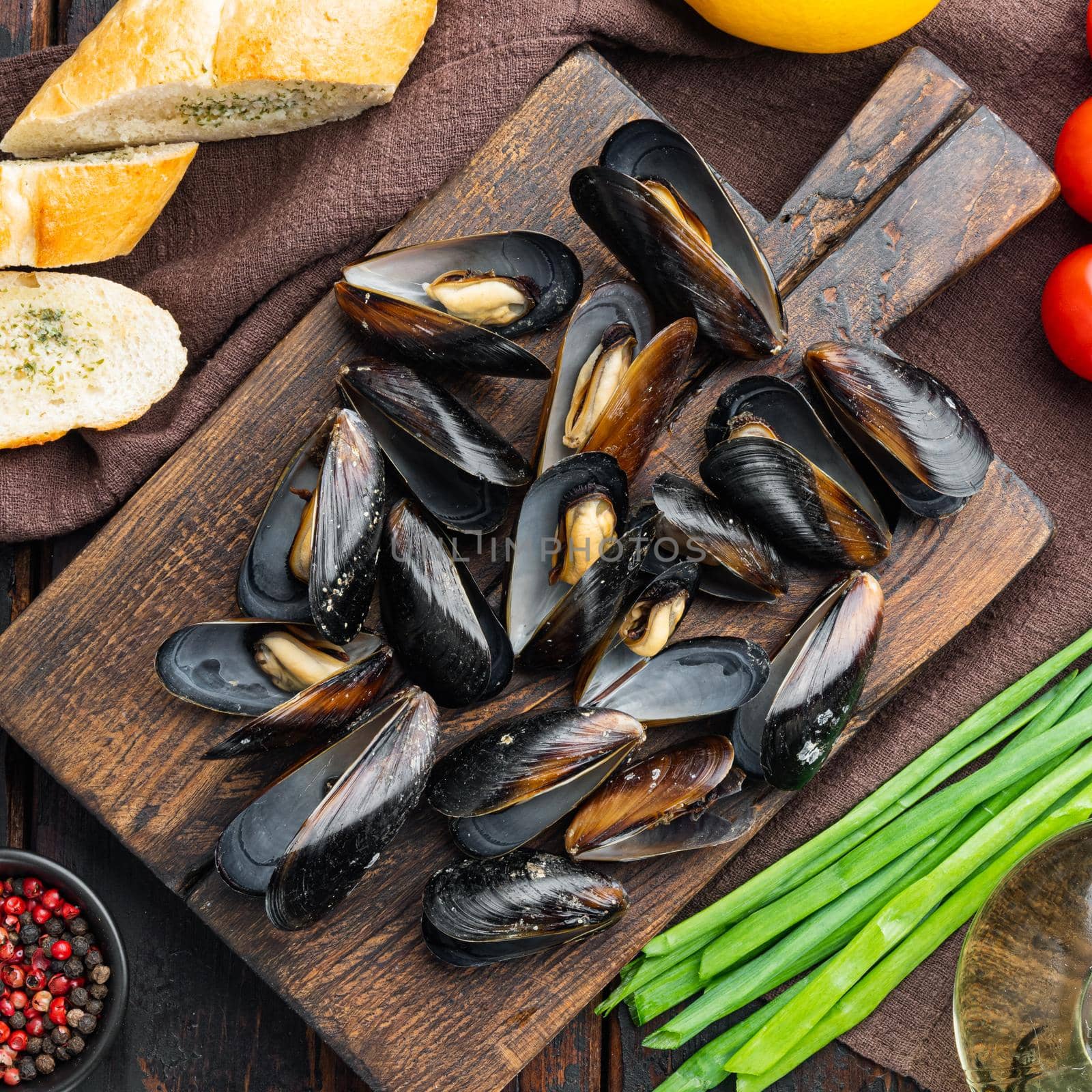 Fresh Mussels with ingredients, on wooden cutting board, on old dark wooden table background, top view flat lay by Ilianesolenyi
