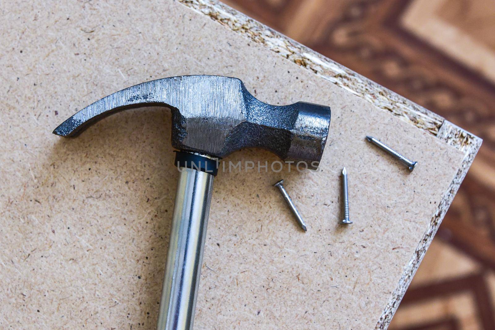 Iron hammer and nails on plywood. wood background.