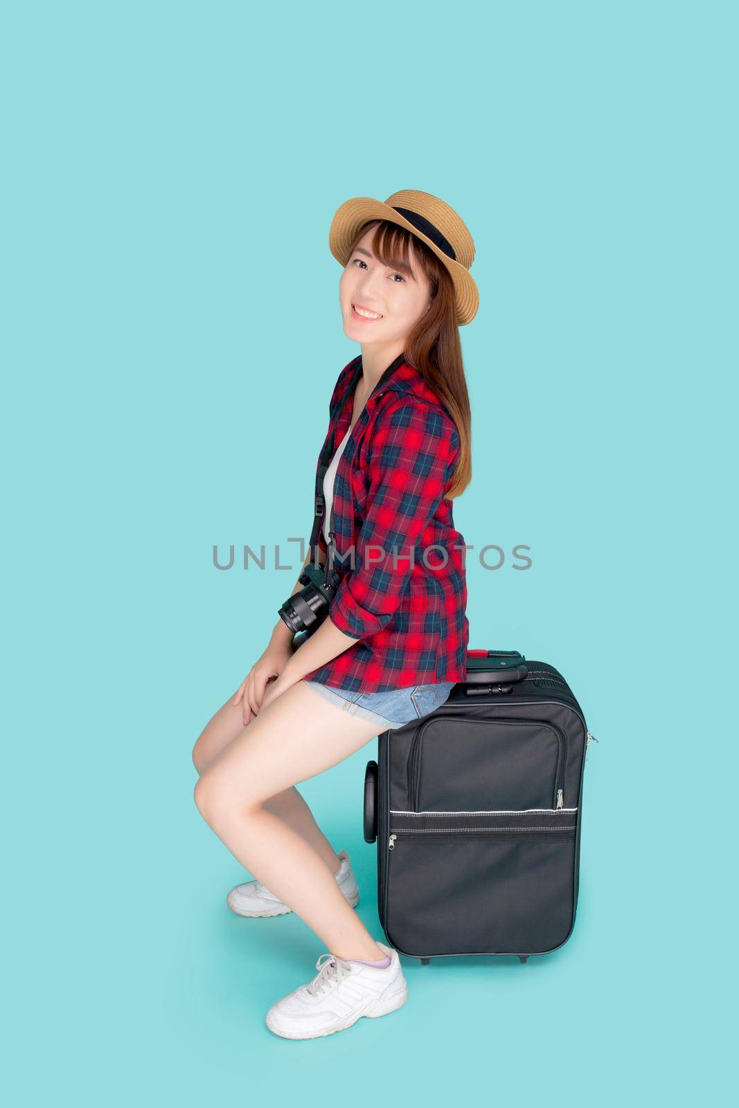 Beautiful portrait young asian woman sitting on luggage smiling and travel summer trip for abroad in vacation, happy asia girl having camera sitting on suitcase for journey with cheerful in holiday. by nnudoo