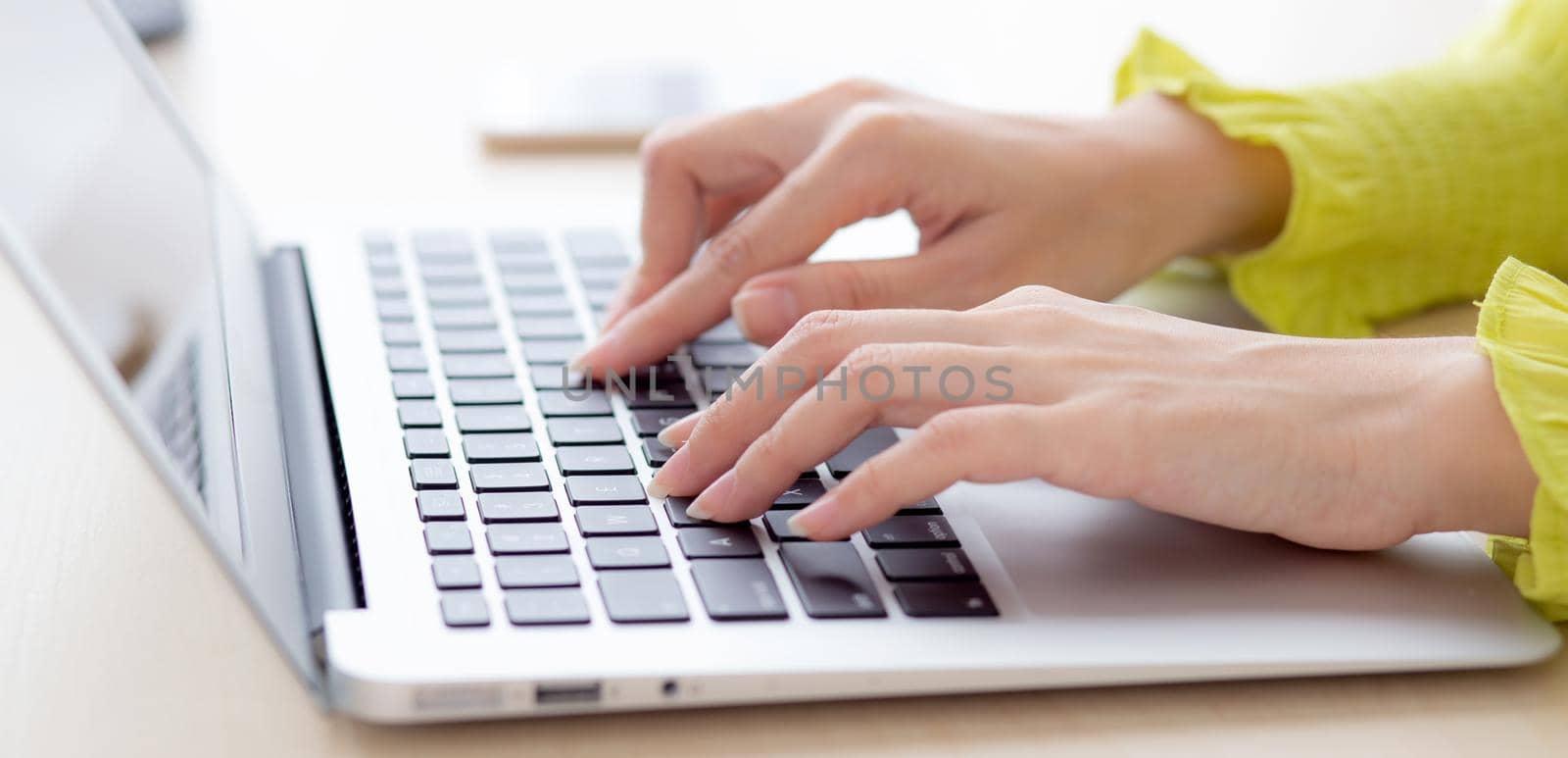 Closeup of hand young asian businesswoman working on laptop computer on desk at home office, freelance looking and typing on notebook on table, woman studying online, business and education concept.