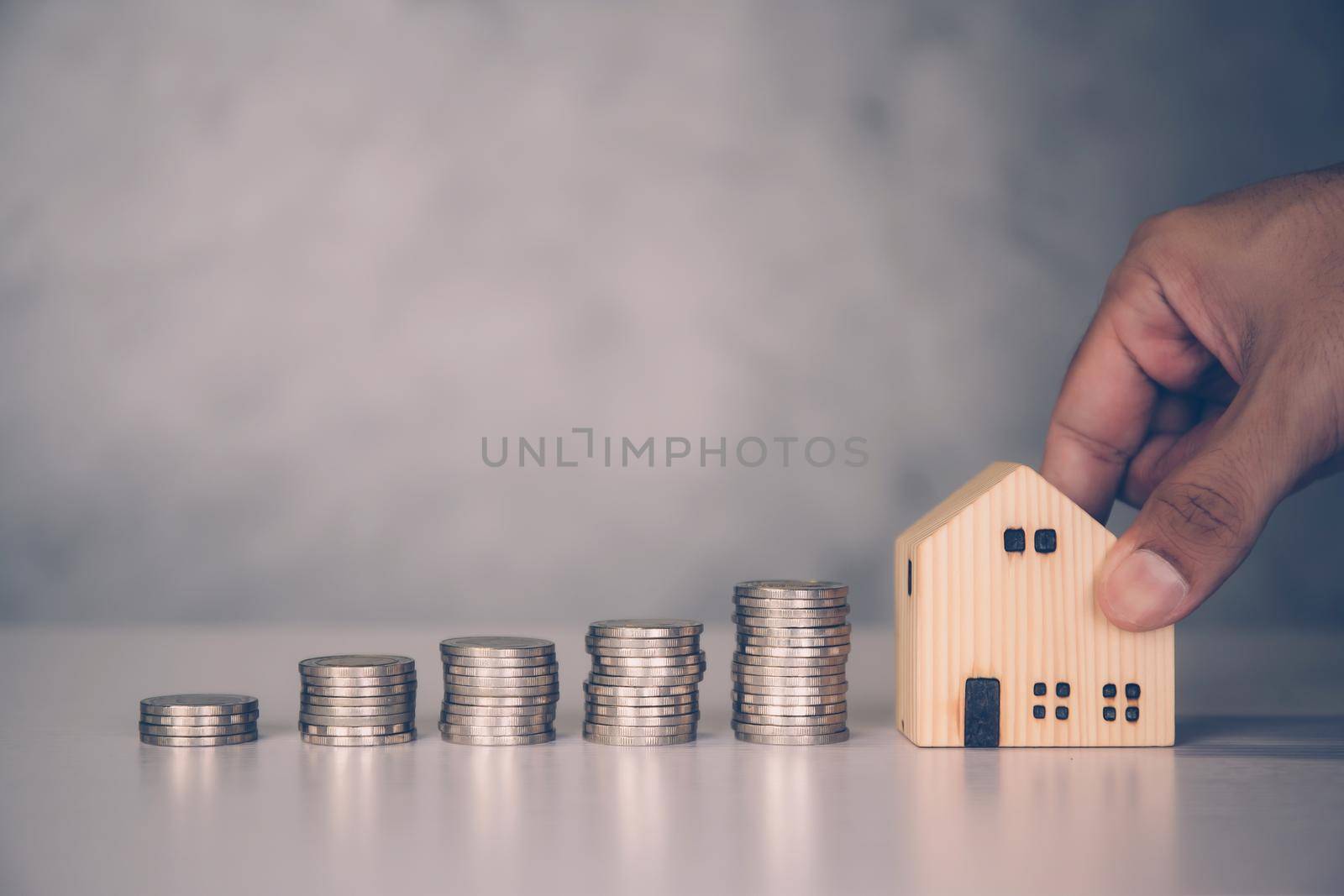 Hands of businessman and stack of coin with saving money for real estate and success, finance and investment, insurance home, deposit and property, residential and financial, business concept. by nnudoo
