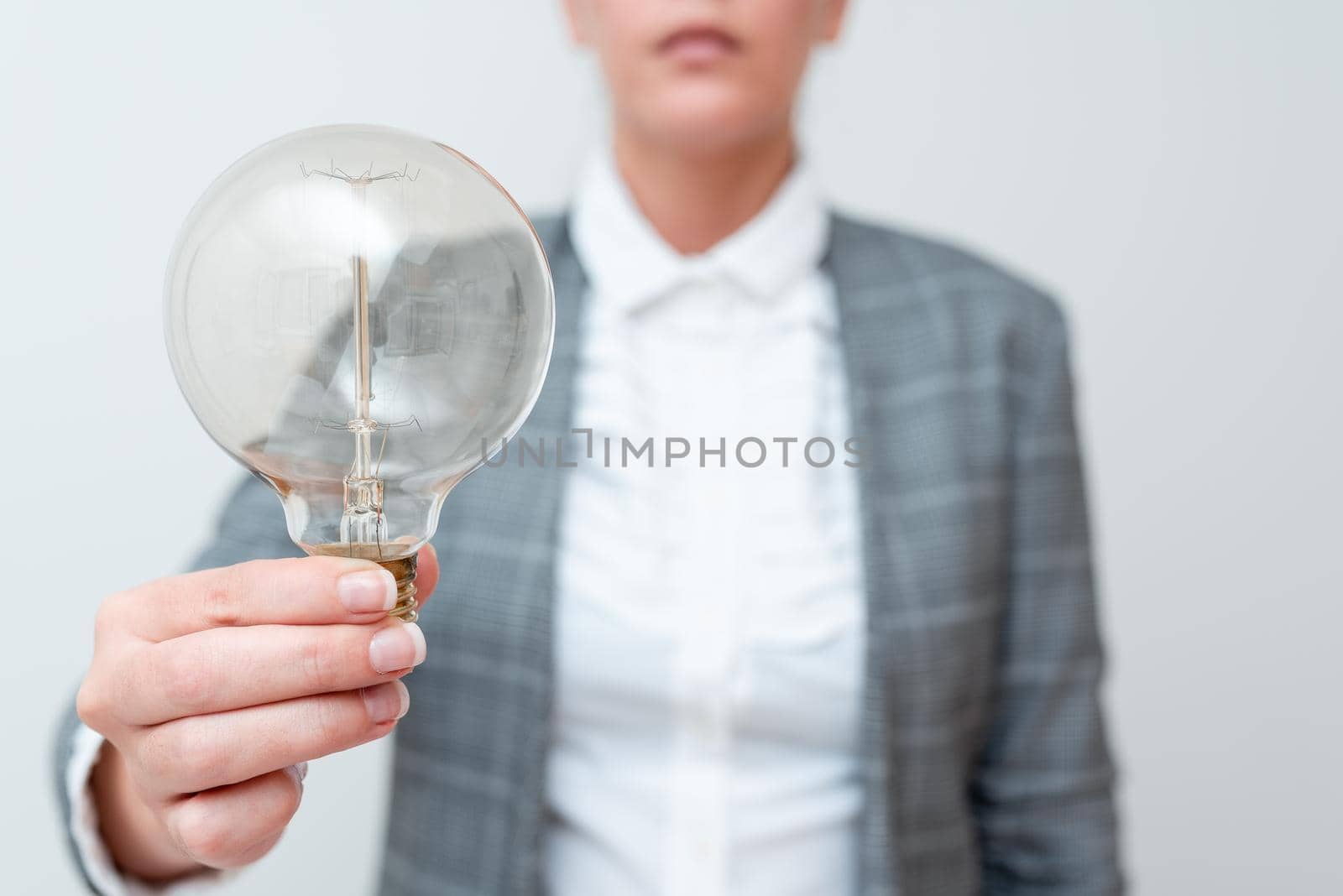 Lady Holding Lamp With Formal Outfit Presenting New Ideas For Project, Business Woman Showing Bulb With One Hand Exhibiting New Technologies, Lightbulb Presenting Another Openion by nialowwa