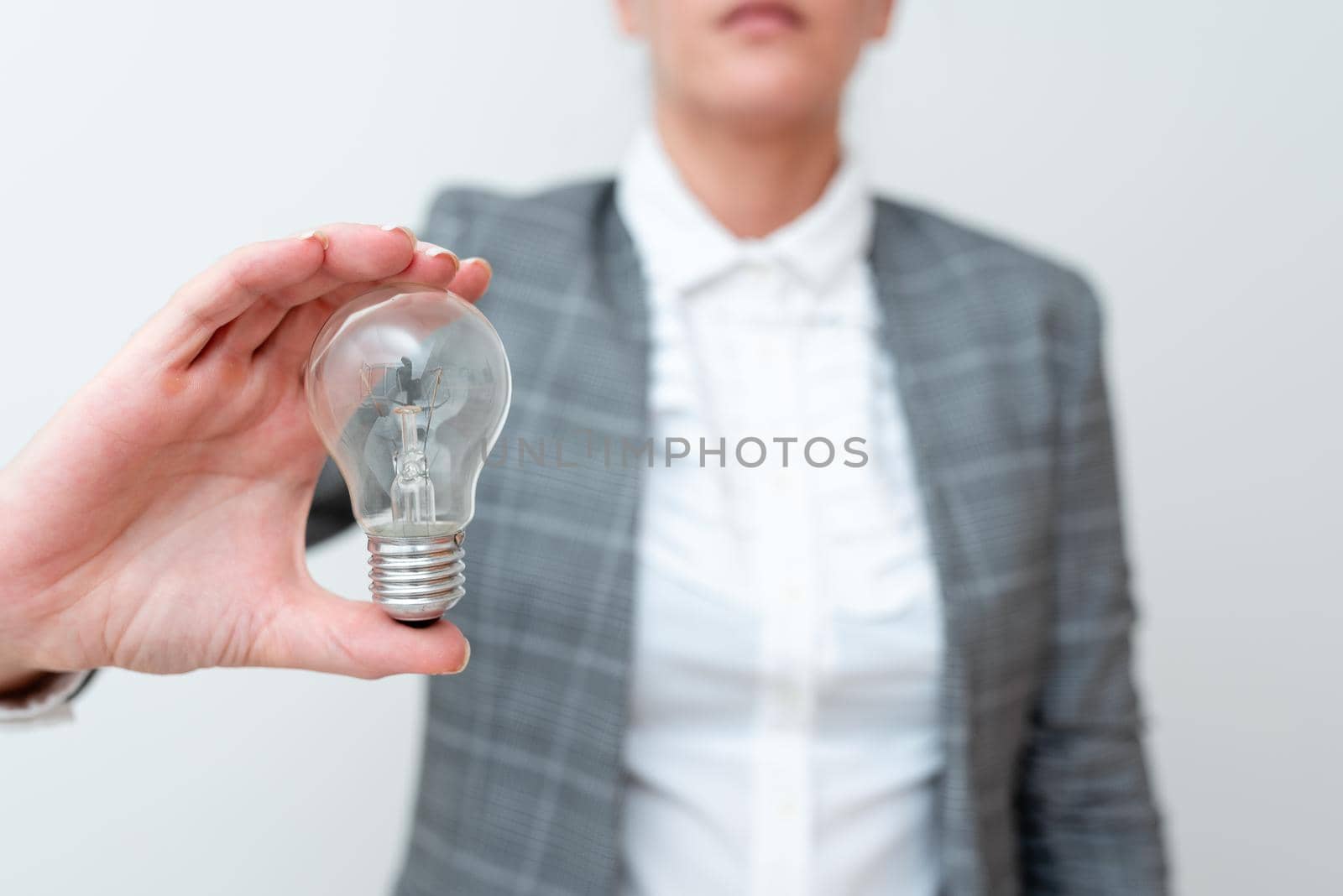 Lady Holding Lamp With Formal Outfit Presenting New Ideas For Project, Business Woman Showing Bulb With One Hand Exhibiting New Technologies, Lightbulb Presenting Another Openion by nialowwa