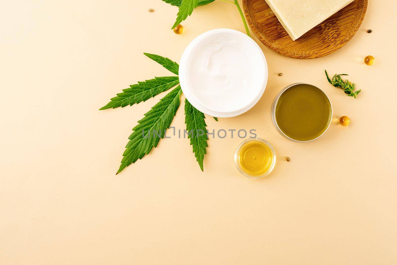 Alternative medicine, natural cosmetics. cbd oil and cannabis leaves cosmetics top view on orange background, flat lay