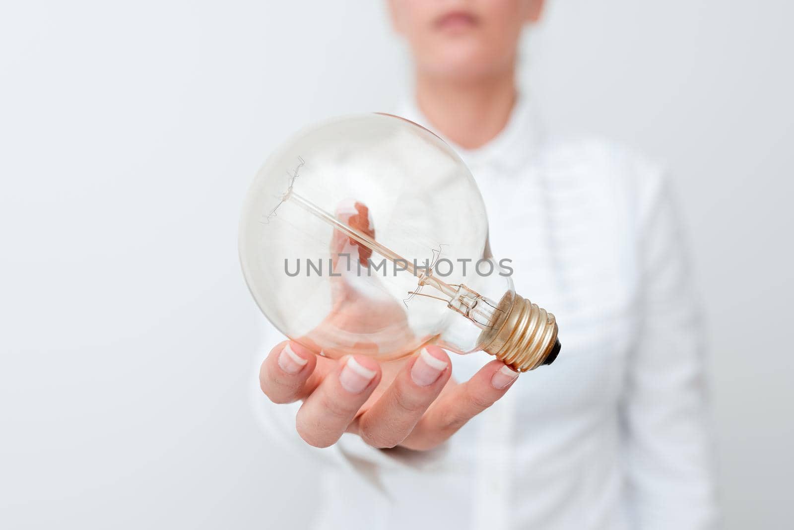 Lady Holding Lamp With Formal Outfit Presenting New Ideas For Project, Business Woman Showing Bulb With One Hand Exhibiting New Technologies, Lightbulb Presenting Another Openion.