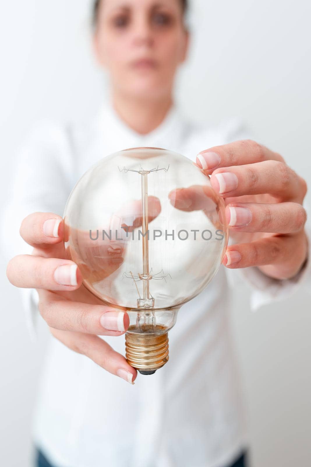 Lady Holding Lamp With Formal Outfit Presenting New Ideas For Project, Business Woman Showing Bulb With Two Hands Exhibiting New Technologies, Lightbulb Presenting Another Openion by nialowwa