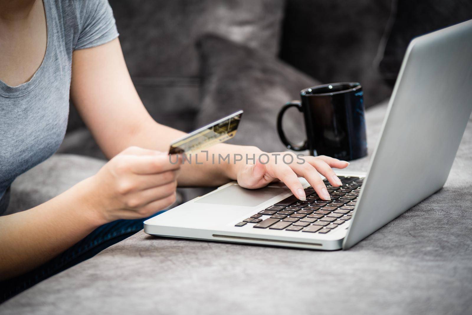 Closeup hand of woman holding SME credit card and using keyboard laptop computer to buy products payment shopping online, spend money, e-commerce, internet banking, working remotely from home concept
