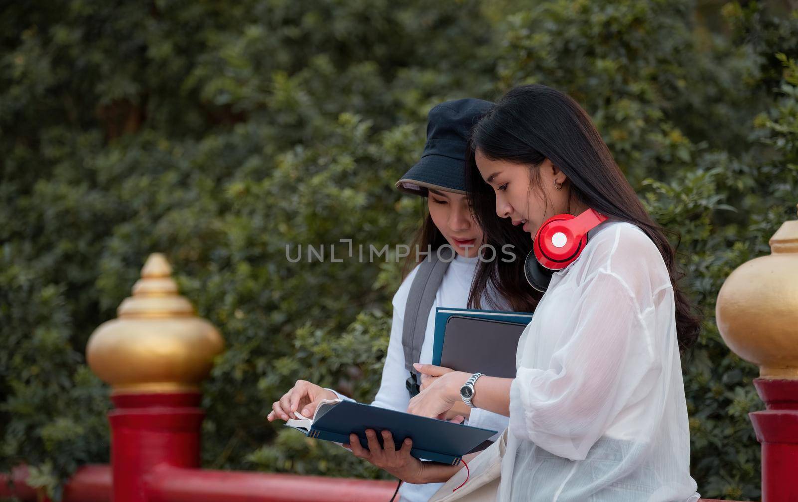 Group of young people reading a book, school folders reading book at high school university campus college knowledge center for learning in summer outdoor.