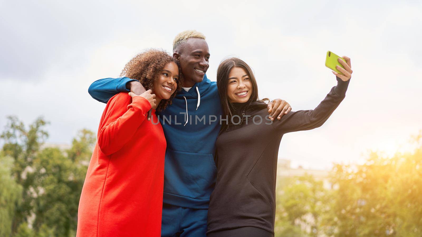 Multi ethnic friends outdoor. Diverse group people Afro american asian spending time together by andreonegin