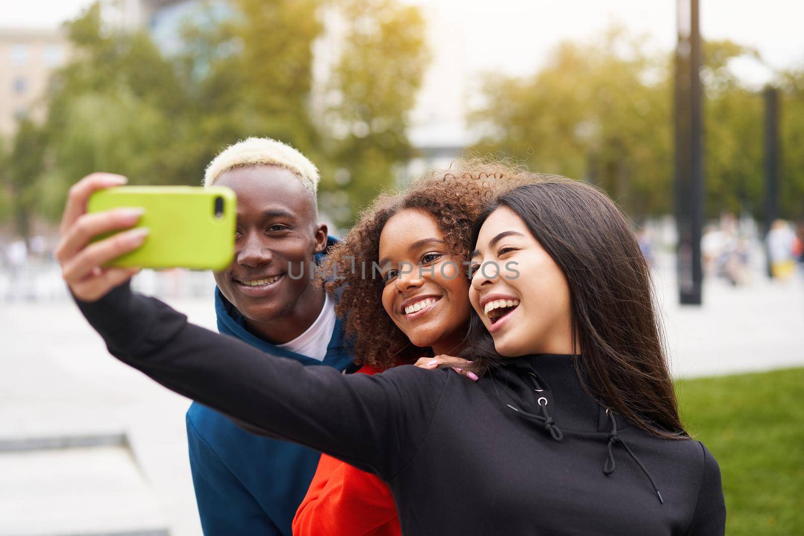 Multi ethnic friends outdoor taking a selfie on smartphone. Diverse group people Afro american asian spending time together Multiracial male female student meeting outdoors