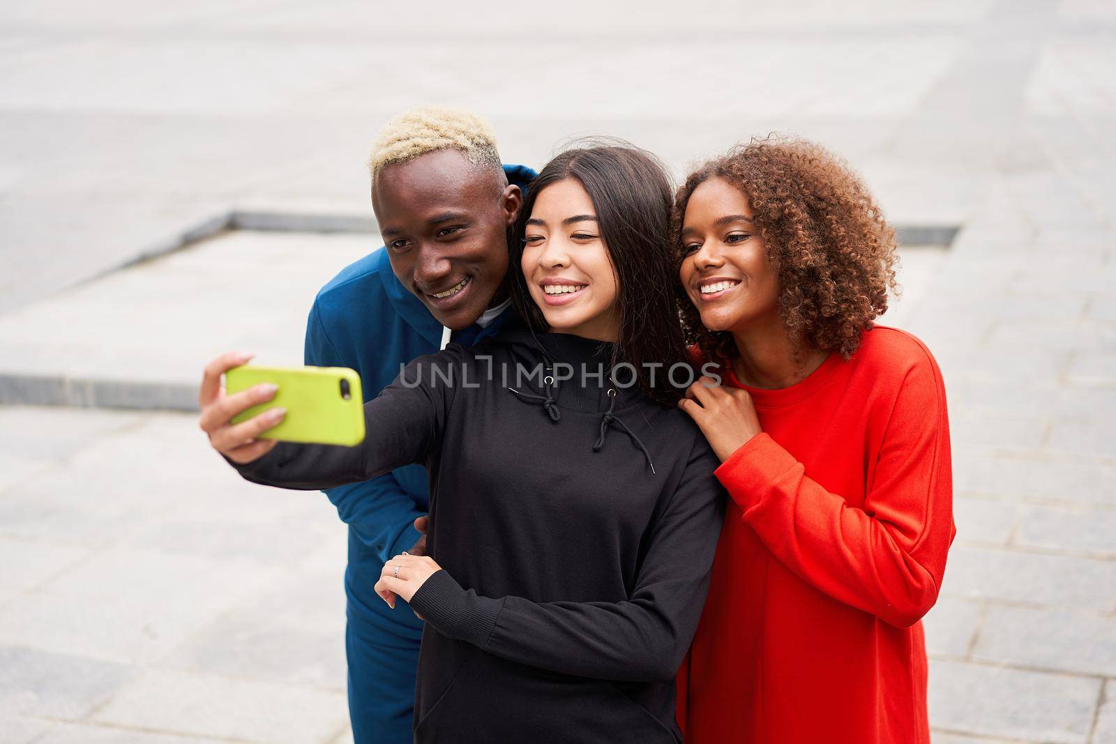 Multi ethnic friends outdoor taking a selfie on smartphone. Diverse group people Afro american asian spending time together Multiracial male female student meeting outdoors