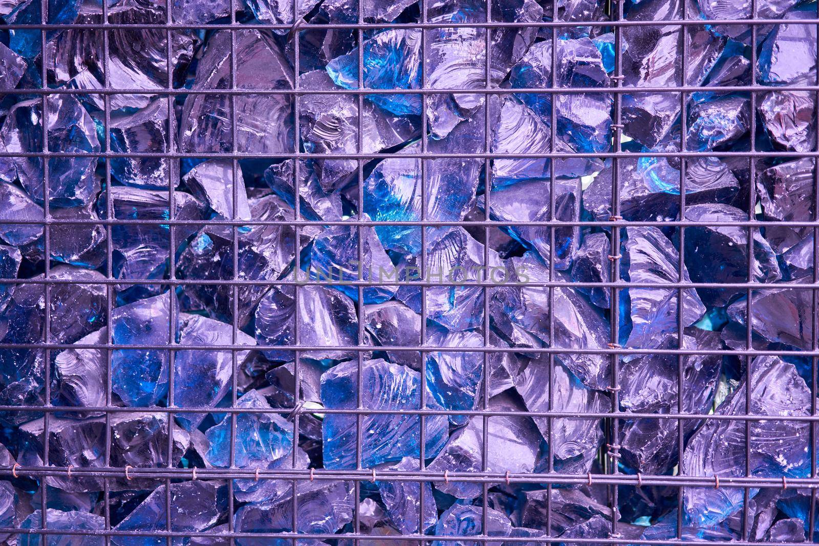 Blue Crystal Mineral Stone. Gems. Artificial crystals in stone cage modern construction wall background Texture of precious and semiprecious stones. colored shiny surface of precious stones.