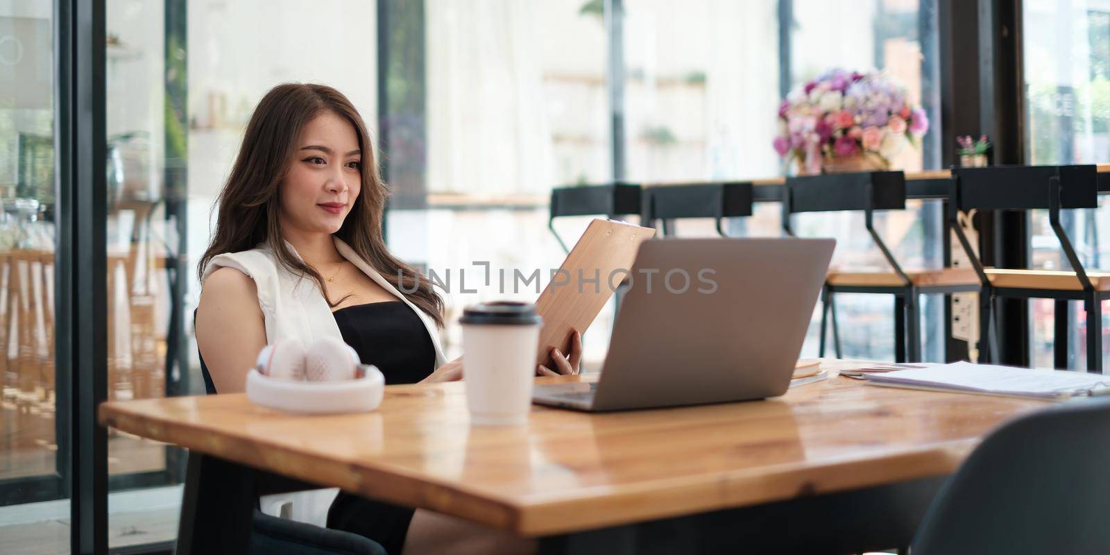 Young woman gammer or blogger influencer sit looking at camera make video conference call recording vlog in living room at her home