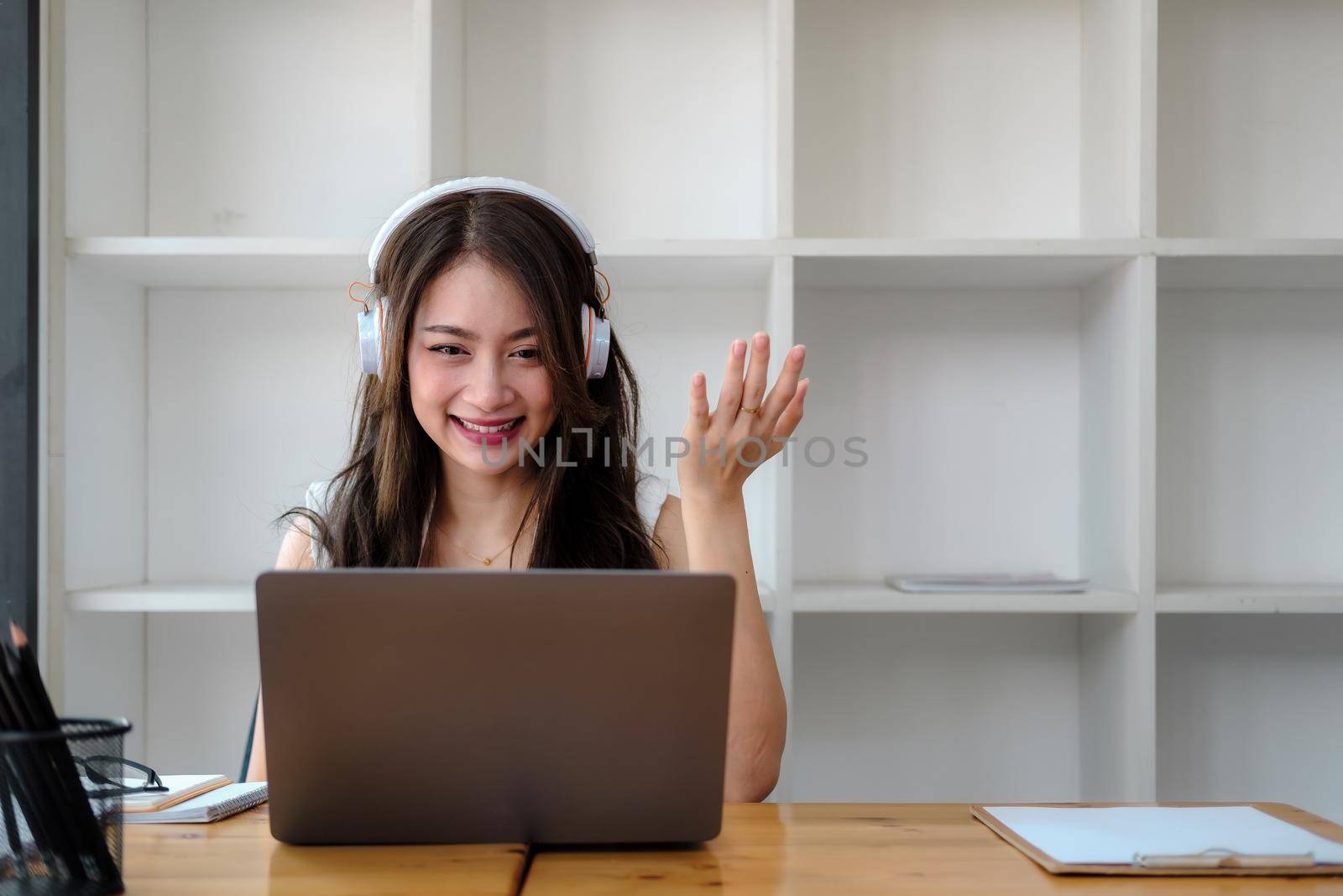 Side view shot smiling asian woman freelancer wearing headset, communicating with client via video computer call. Millennial pleasant professional female tutor giving online language class by nateemee