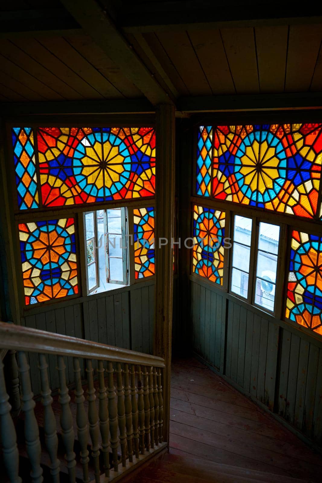 Authentic balcony of an old residential building with a stained glass window made of multicolored mosaics.