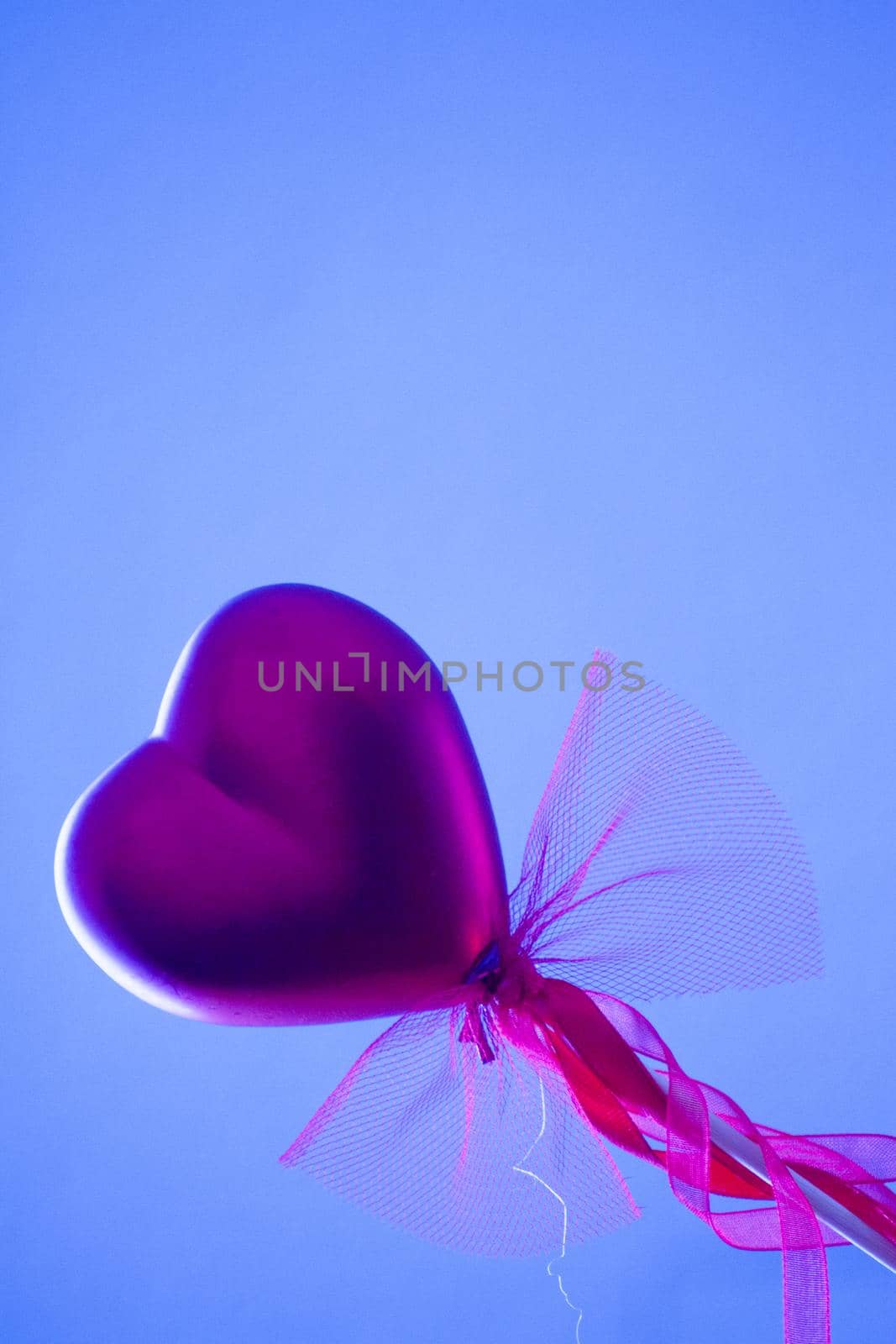Red heart attached to a stick with a bow hanging by GemaIbarra
