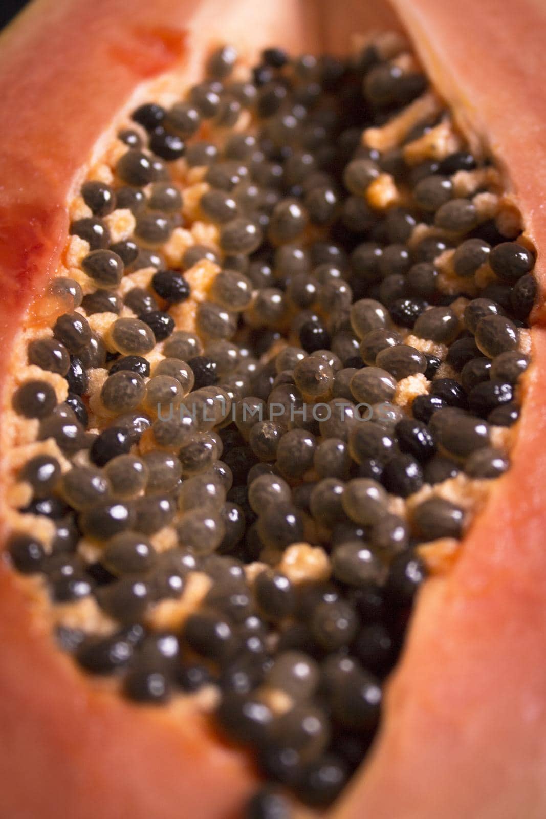 Half of an open papaya with the seeds. No people