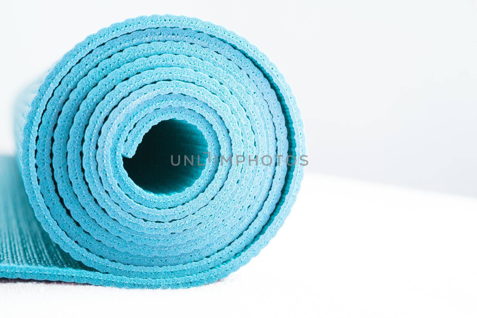 Rolled up yoga or pilates mat. No people