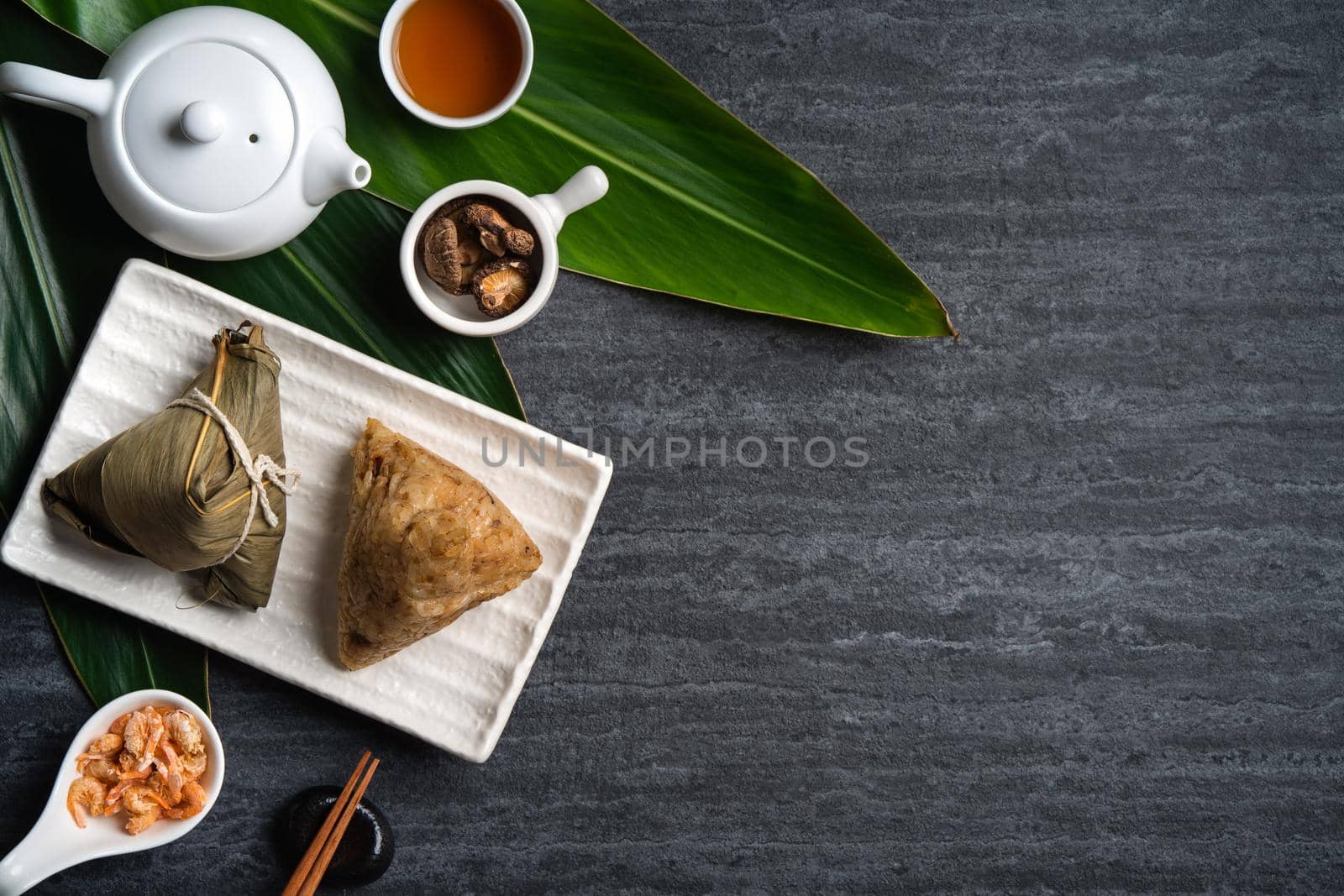 Zongzi. Rice dumpling top view design concept for Chinese traditional Dragon Boat Festival (Duanwu Festival) over dark black slate background.