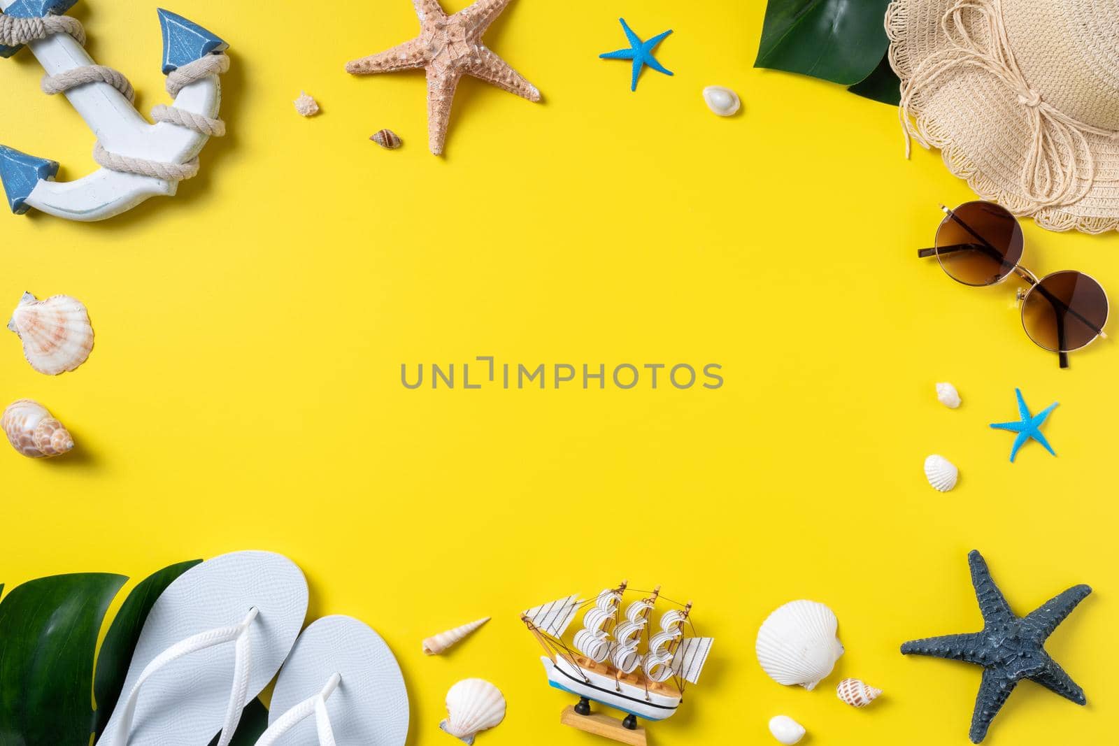 Summer beach design concept. Top view of holiday travel with shells, hat, slipper on yellow background.