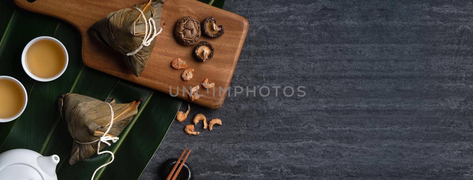 Zongzi. Rice dumpling top view design concept for Chinese traditional Dragon Boat Festival (Duanwu Festival) over dark black slate background.