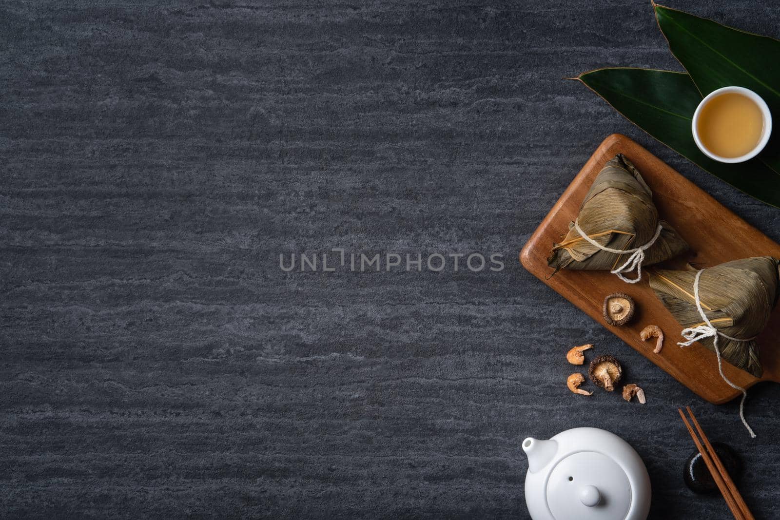 Zongzi. Rice dumpling top view design concept for Chinese traditional Dragon Boat Festival (Duanwu Festival) over dark black slate background.