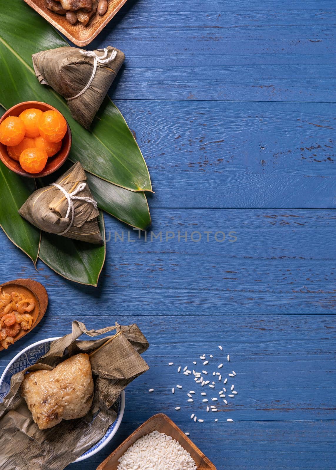 Zongzi rice dumpling with ingredients top view for Chinese traditional Dragon Boat Festival (Duanwu Festival) over blue wooden table background.