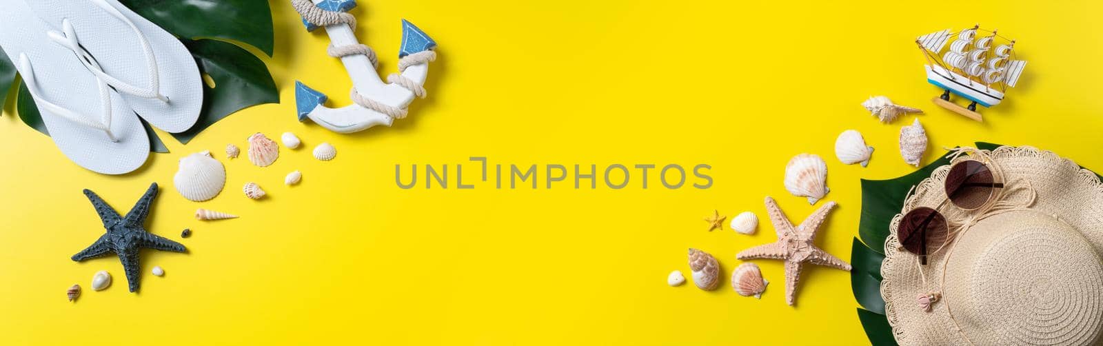 Summer beach design concept. Top view of holiday travel with shells, hat, slipper on yellow background.