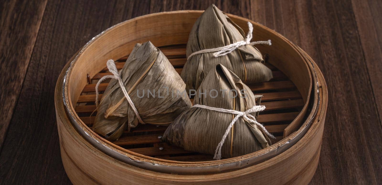 Zongzi rice dumpling for Chinese traditional Dragon Boat Festival (Duanwu Festival) over dark background.