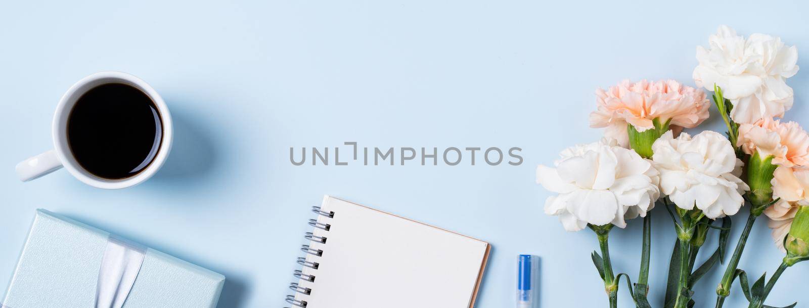Design concpet of Mother's Day greeting with carnation flower, holiday gift idea and notebook diary on mother's desk background.