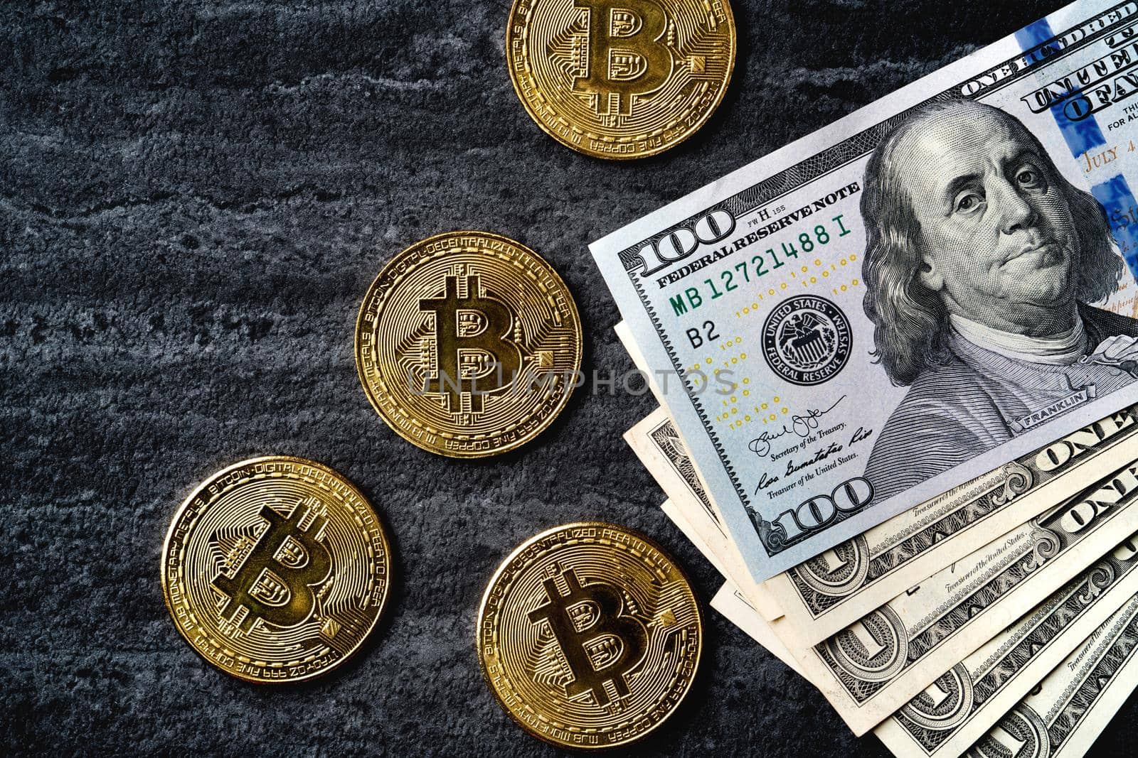 Business top view design concept of cryptocurrency bitcoin with USD Dollar paper currency money over dark black table background.