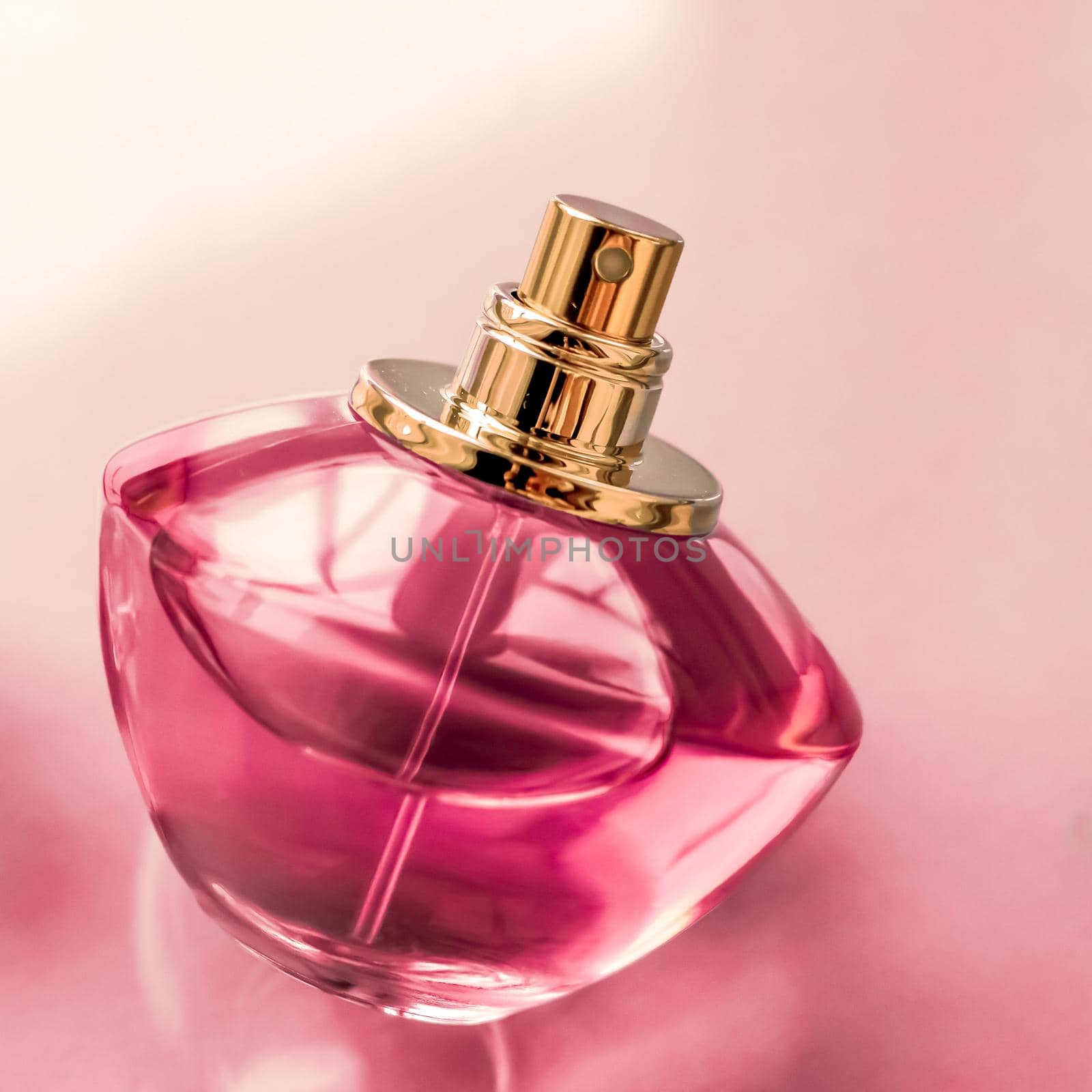 Perfumery, spa and branding concept - Pink perfume bottle on glossy background, sweet floral scent, glamour fragrance and eau de parfum as holiday gift and luxury beauty cosmetics brand design