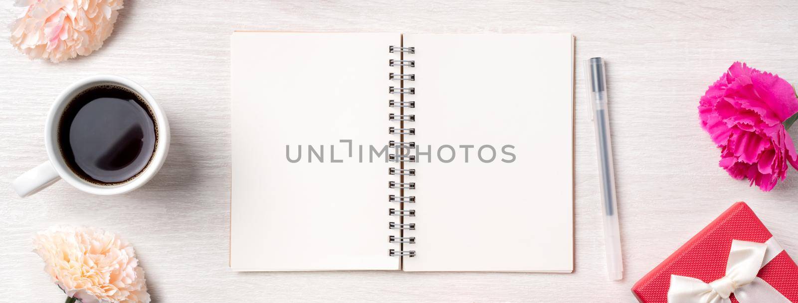 Design concpet of Mother's Day greeting with carnation flower, holiday gift idea and notebook diary on mother's desk background.