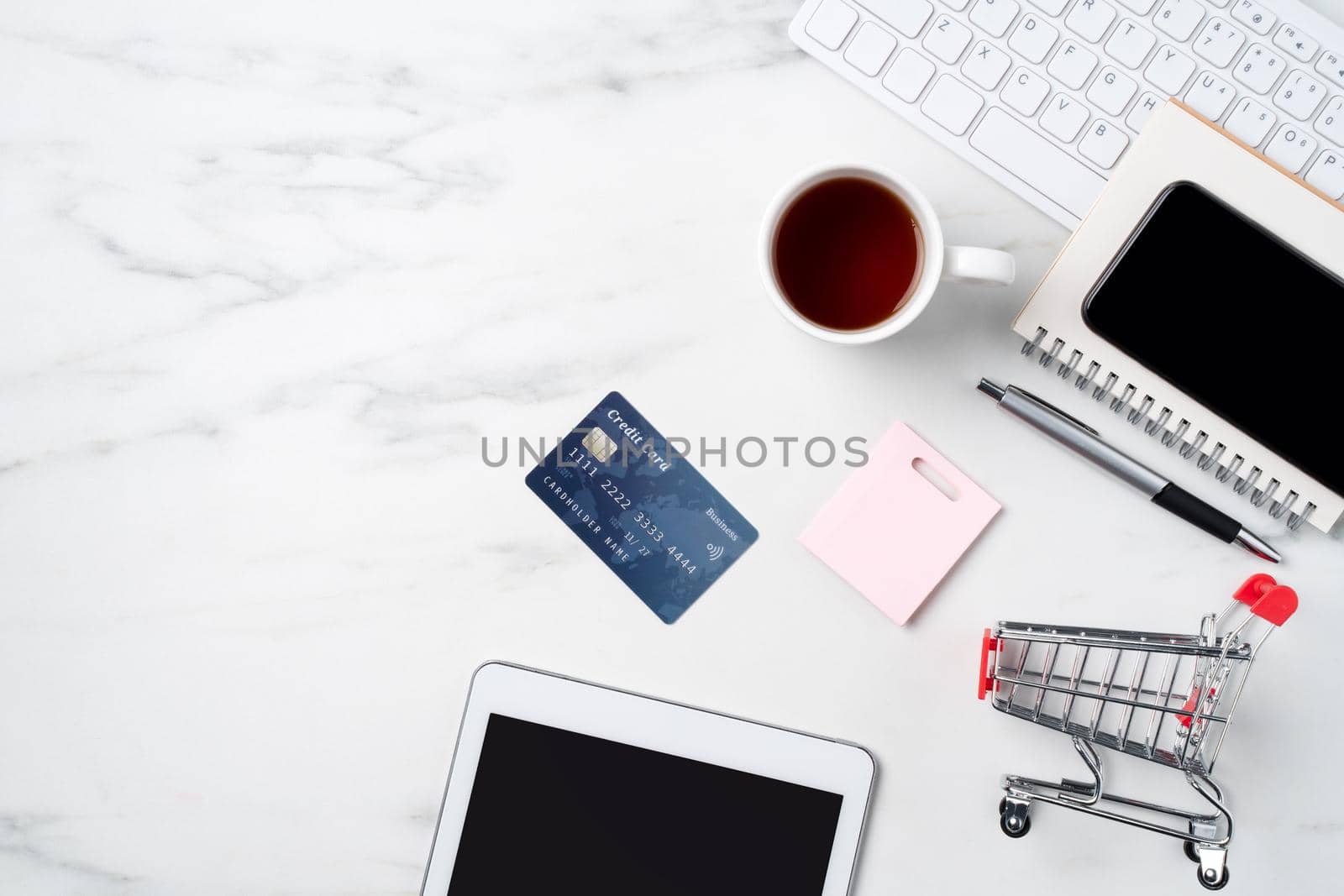 Top view of online shopping concept with credit card and electronics isolated on office marble white table background.