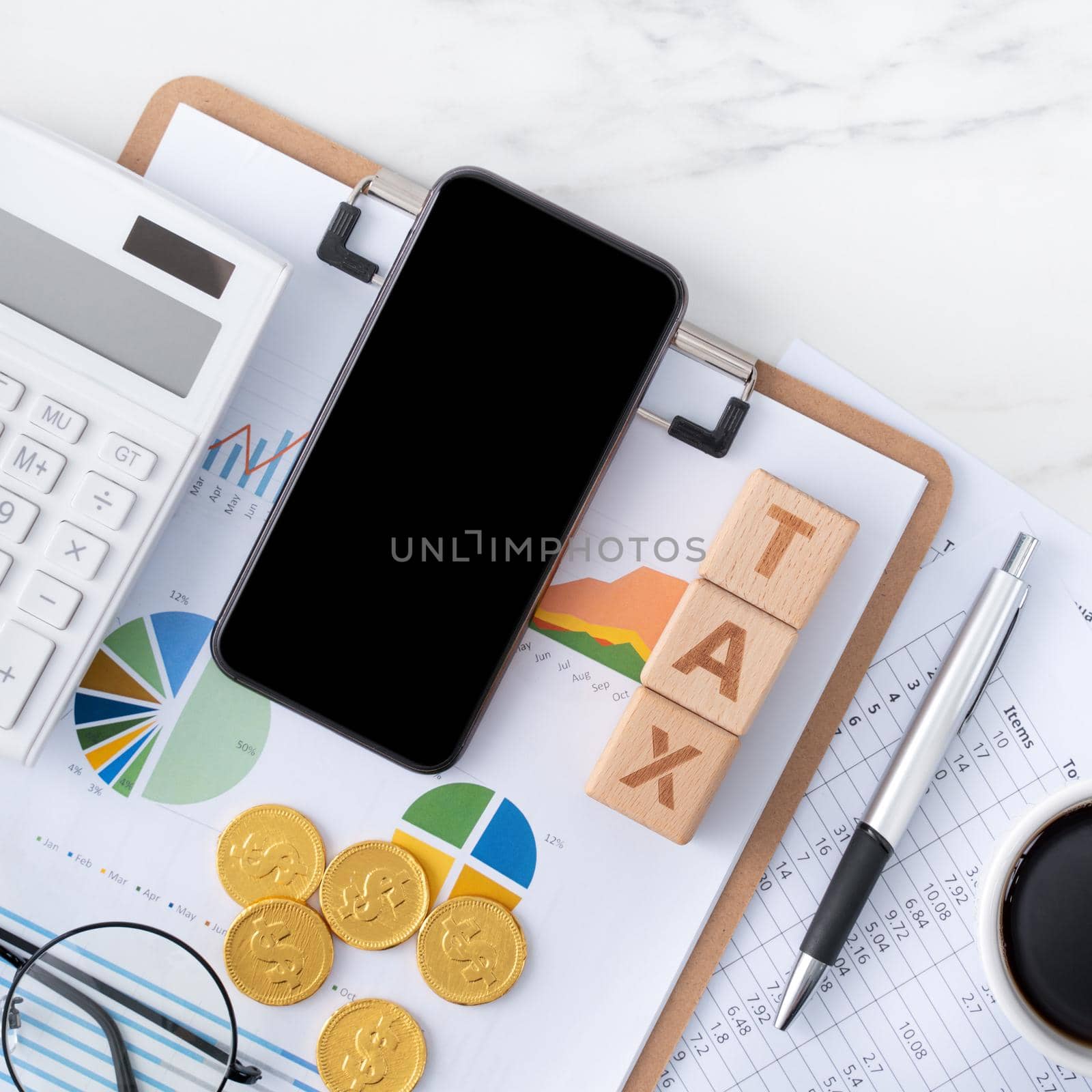 Top view of reading the overview and calculating, paying tax with smart phone from internet.
