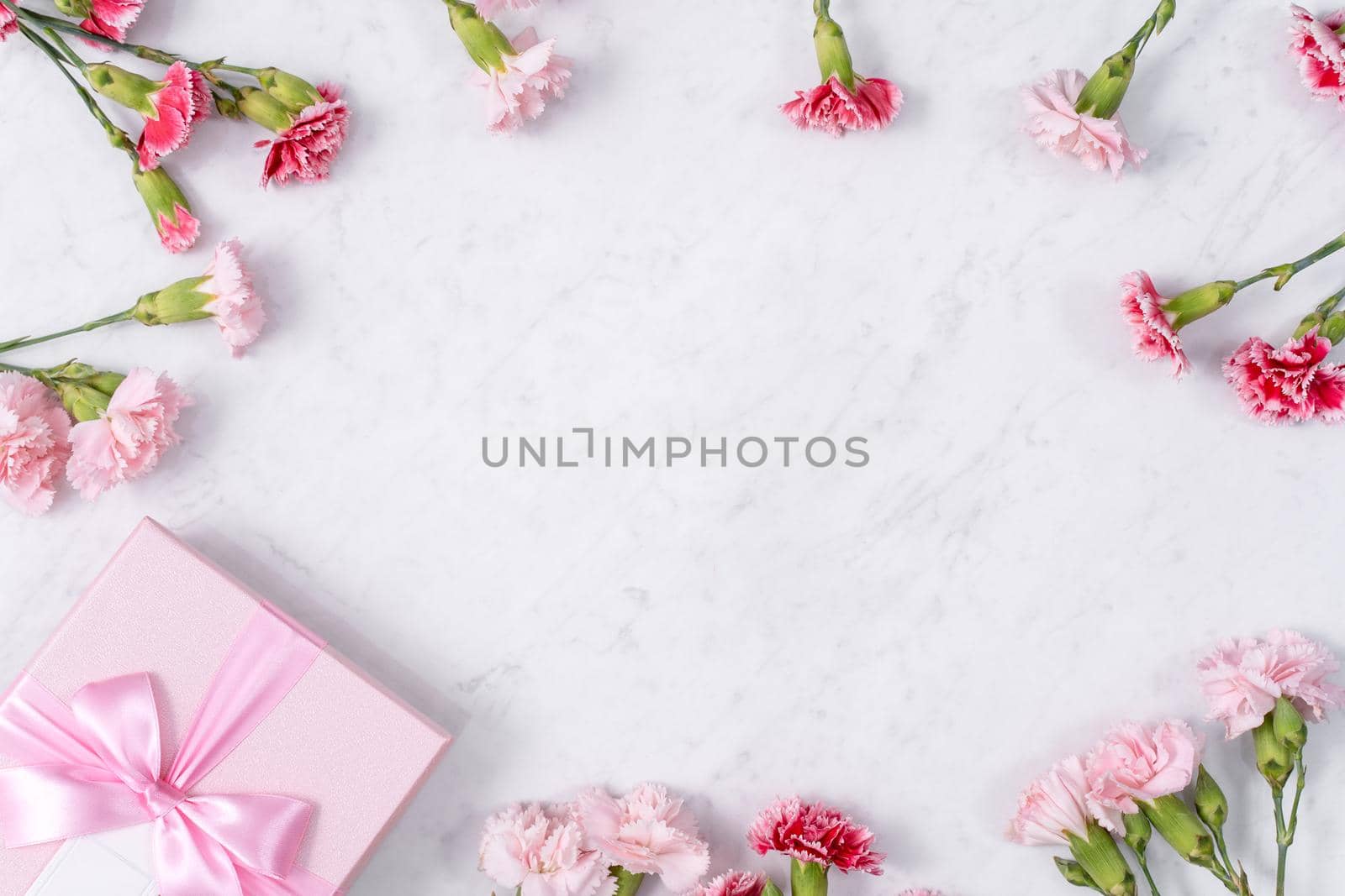 Concept of Mother's day holiday greeting gift design with carnation bouquet on white marble background