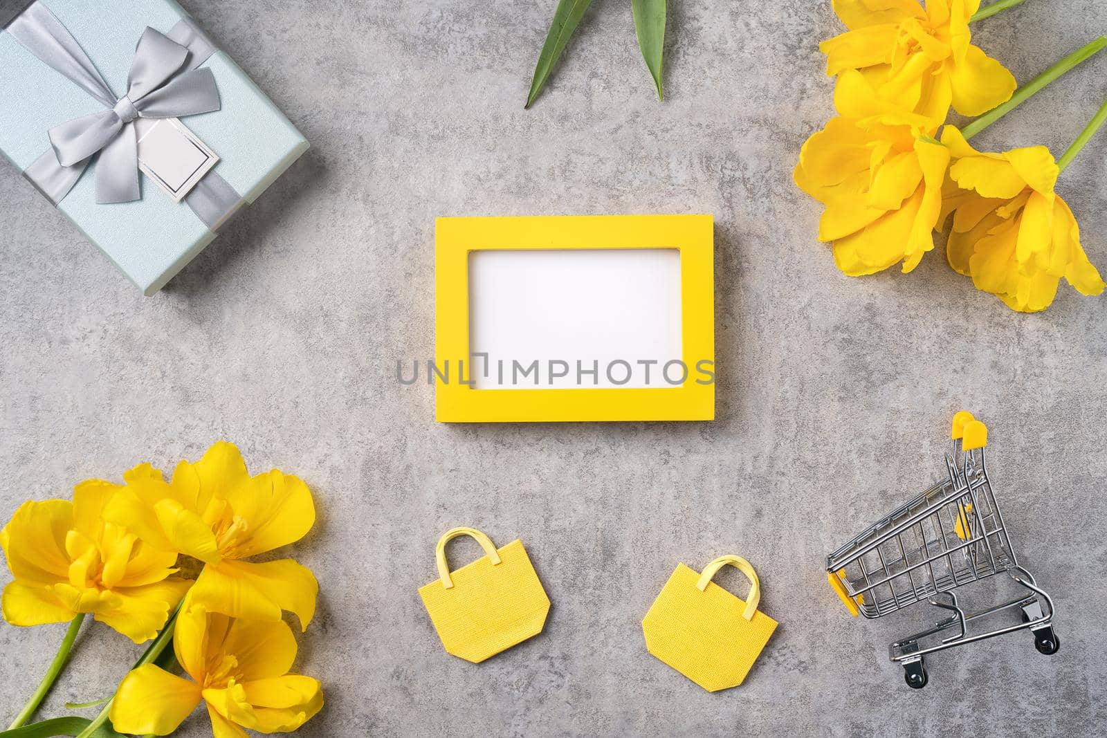 Concept of Mother's day holiday gift shopping greeting design with yellow tulip flower bouquet on gray background