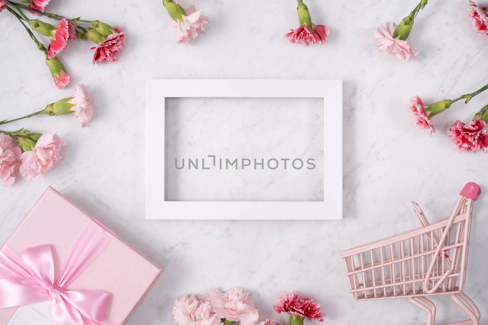 Concept of Mother's day holiday greeting design with carnation bouquet and gift on white marble background