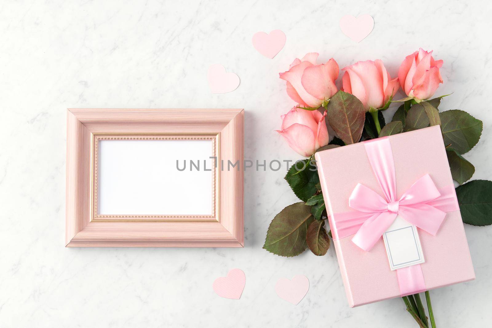 Giftbox and pink rose flower on marble white table background for Valentine's Day holiday greeting design concept.