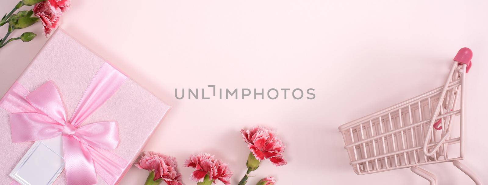 Concept of Mother's day holiday greeting design with carnation bouquet and gift on pink background