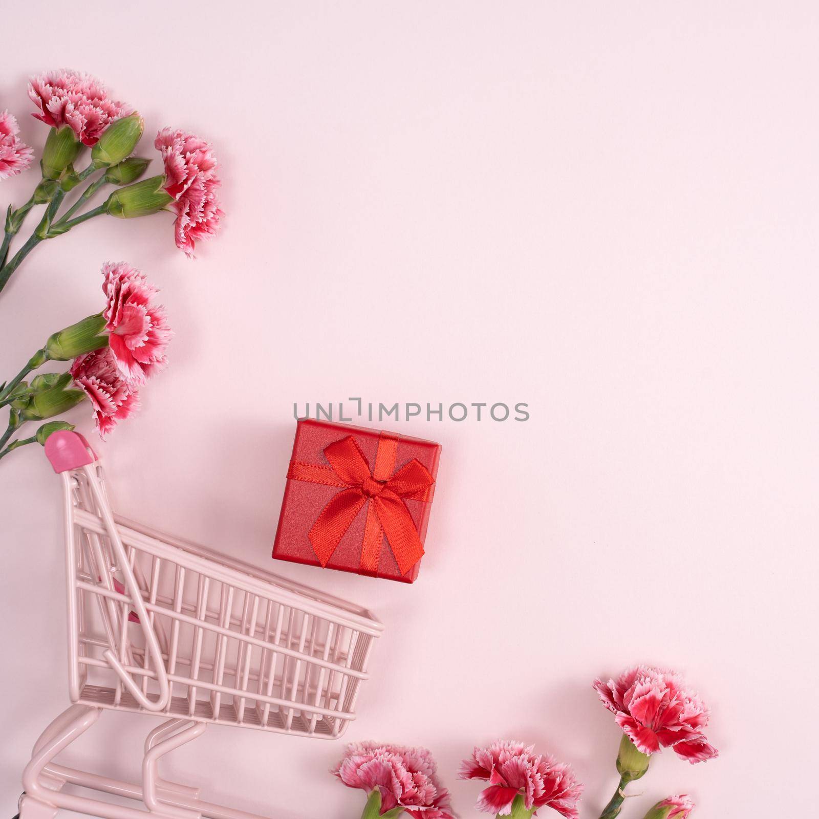 Concept of Mother's day holiday greeting design with carnation bouquet and gift on pink background